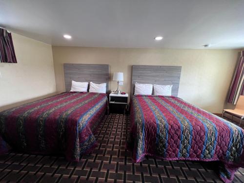 ein Hotelzimmer mit 2 Betten und einem Tisch mit einer Lampe in der Unterkunft FairBridge Inn Express in Milford