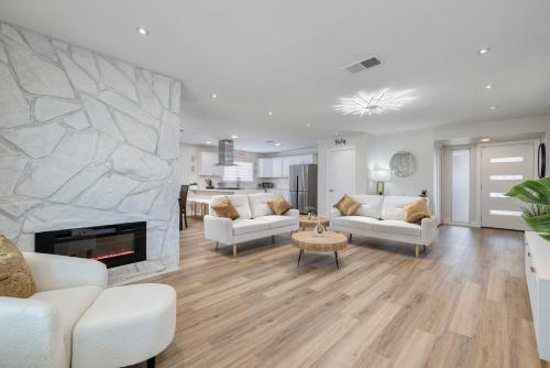 a living room with white furniture and a stone fireplace at Single Story minutes from Summerlin with RV Parking & Dog Friendly in Las Vegas