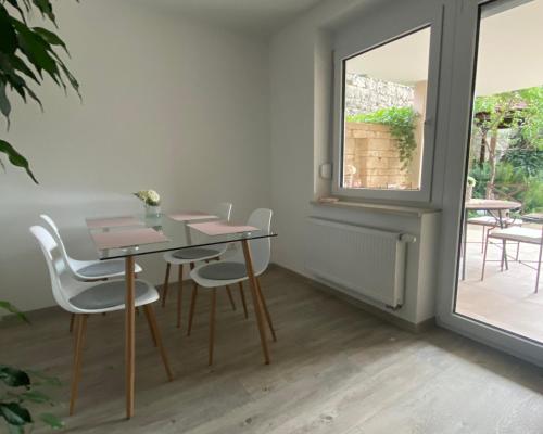 a table and chairs in a room with a window at ST-Apartment Charming 1 mit Terrasse und Garten, 3 Zimmer in Geislingen in Geislingen an der Steige