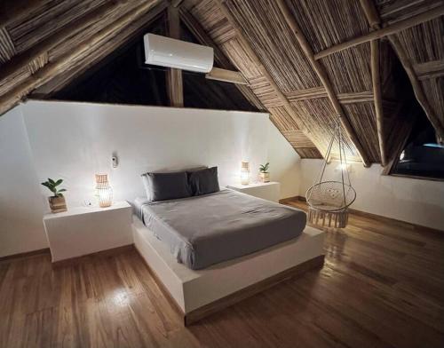 波波尤的住宿－Jungle Shacks : Hoku Casita，铺有木地板的客房内设有一间卧室和一张床。