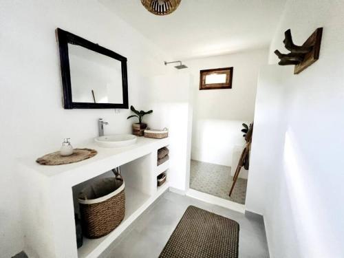 a white bathroom with a sink and a mirror at Jungle Shacks : Hoku Casita in Popoyo