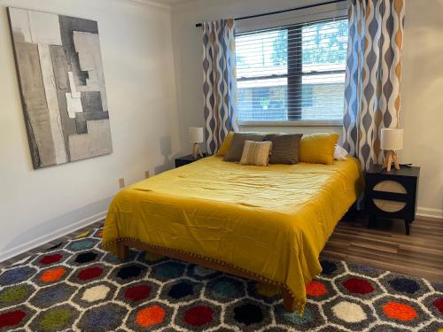 a bedroom with a bed with a yellow bedspread and a window at Lucky #9 Hot Springs in Hot Springs