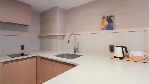 a kitchen with a sink and a counter top at Geoje Mongdol Beach H Avenue Hotel in Geoje 