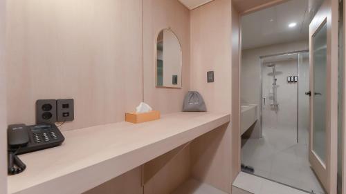 a bathroom with a phone sitting on a counter at Geoje Mongdol Beach H Avenue Hotel in Geoje 
