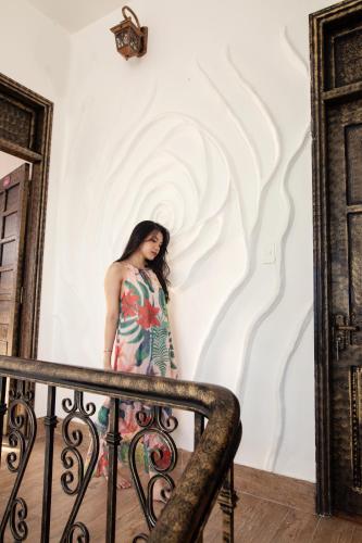 a woman in a dress standing on a staircase at HELLO VILLA & SPA in Hue