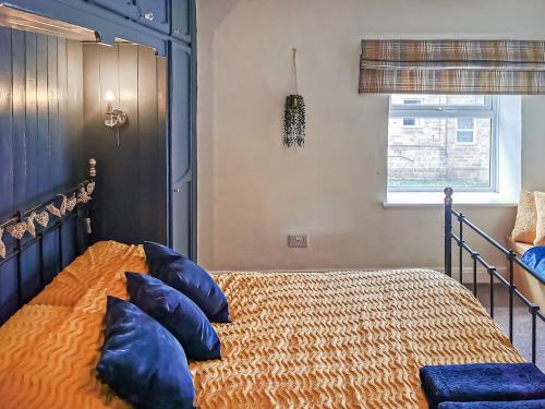 a bedroom with a bed with blue pillows at Cosy Nook in Cromford
