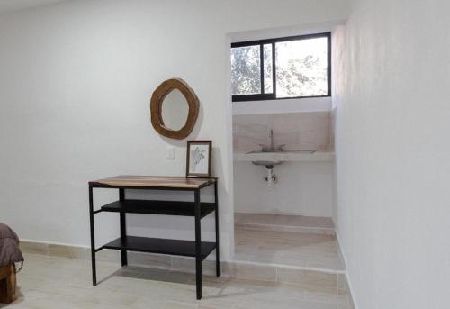 a bathroom with a sink and a table with a mirror at 3B Departamentos in Tizimín