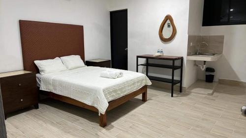 a bedroom with a bed and a sink and a mirror at 3B Departamentos in Tizimín
