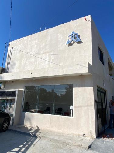 a white building with a sign on the side of it at 3B Departamentos in Tizimín