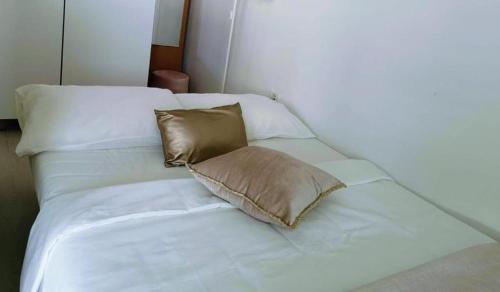 a white bed with two pillows on top of it at Apartmaji Koper - MARINA STYLE in Koper