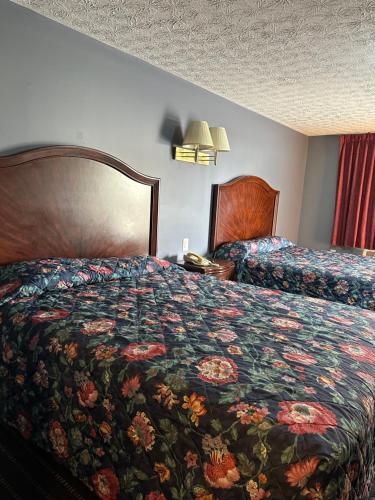 een hotelkamer met een bed met een bloemenbed bij Marjon Motel in Anderson
