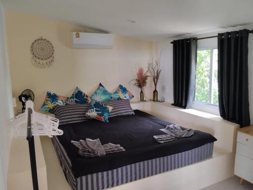 a bedroom with a bed with pillows and a window at Dream seaview bungalows in Haad Pleayleam