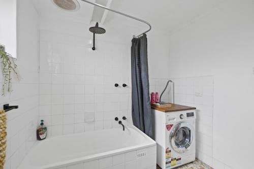 a bathroom with a washer and a washing machine at Golden Sands in Henley Beach South