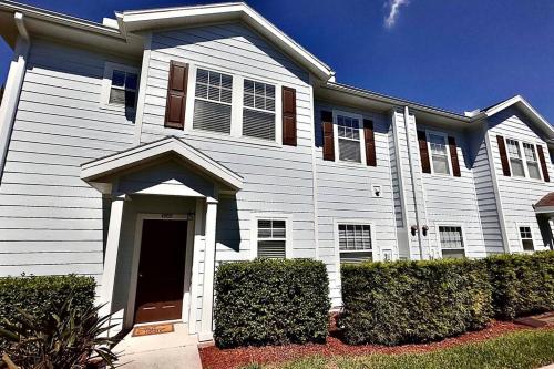 a white house with bushes in front of it at ABC Vacation Homes in Kissimmee
