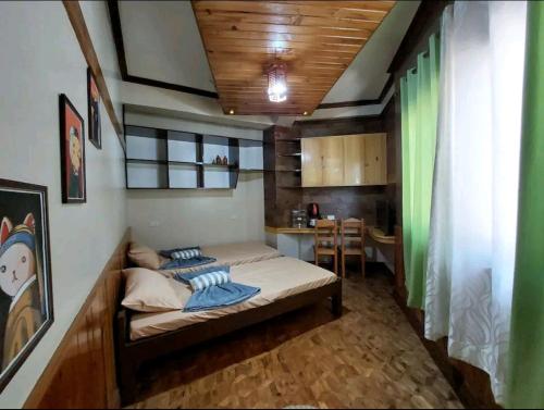 Un dormitorio con una cama y una mesa. en Simple Room in a Transient House en Baguio