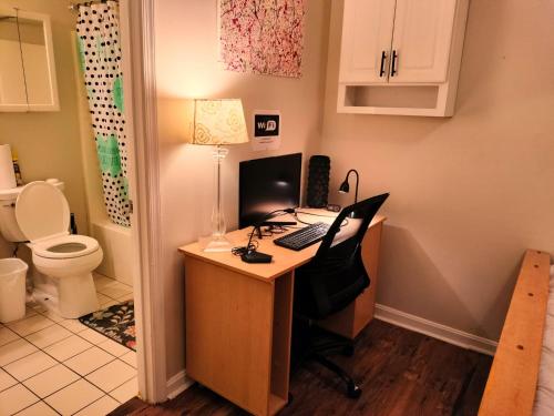 een bureau met een computer en een toilet bij Luxury Basement Apartment LA CASA in Winchester