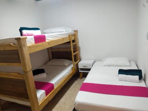 1 dormitorio con 2 literas y toallas. en Alquiler por días en Armenia Casahotel Villahermosa en Armenia
