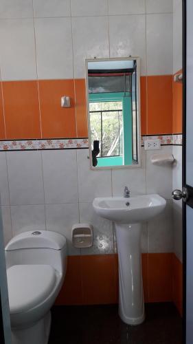 W łazience znajduje się umywalka, toaleta i lustro. w obiekcie HOSPEDAJE TURISTICO REAL MADRID w mieście La Merced