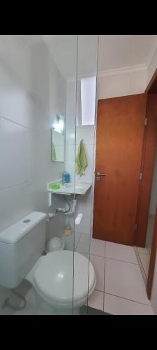 een badkamer met een toilet en een glazen douche bij Cantinho do Boris III in Ubatuba