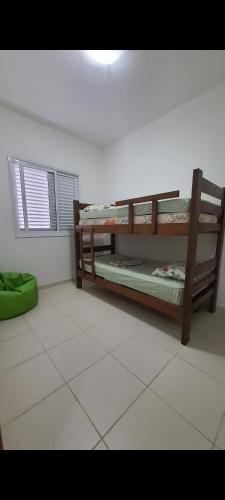 een kamer met 2 stapelbedden op een tegelvloer bij Cantinho do Boris III in Ubatuba