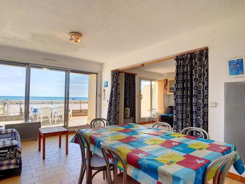 une salle à manger avec une table et une vue sur l'océan dans l'établissement Carnon: Apt FF3, 8-10 pers, Accès Plage, Parking - FR-1-715-83, à Mauguio