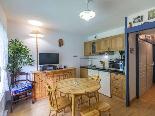 une cuisine avec une table en bois et une salle à manger dans l'établissement Appartement cosy à Cauterets - 4 pers, jardin, parking, proche centre et thermes. - FR-1-401-265, à Cauterets