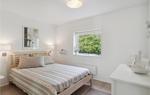 a white bedroom with a bed and a window at Nice Home In Vejby With Kitchen in Vejby