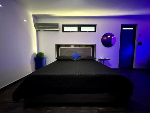 アグアディヤにあるPasavento - Family Modern Suiteの紫の部屋に黒いベッドが備わるベッドルーム1室