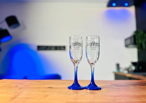 two wine glasses sitting on top of a wooden table at Pasavento - Family Modern Suite in Aguadilla