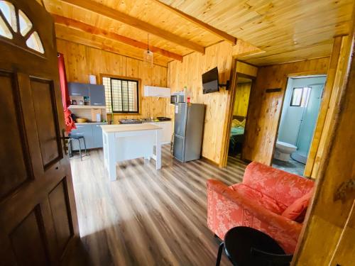 a kitchen and living room in a log cabin at Cabañas EMC in Los Vilos