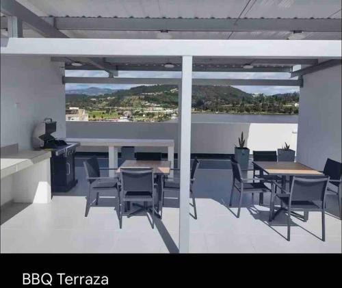 Pokój ze stołem i krzesłami oraz balkonem w obiekcie Apartamento con vista al lago. w mieście Paipa