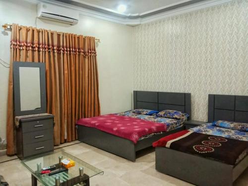 1 Schlafzimmer mit 2 Betten und einem Spiegel in der Unterkunft Family Guest House in Gulshan-e-iqbal , block-10 in Karatschi