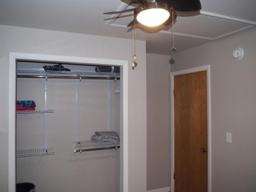 a room with a ceiling fan and a closet at Manist-easy - Lakefront With Dock And Kayaks! in Kalkaska
