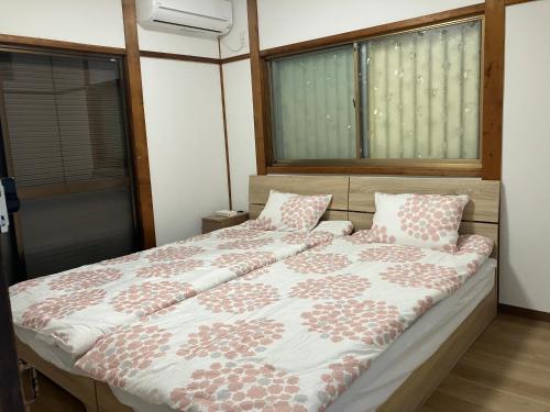ein Schlafzimmer mit einem großen Bett mit Kissen darauf in der Unterkunft りんくう館笠松 関西空港 in Sano