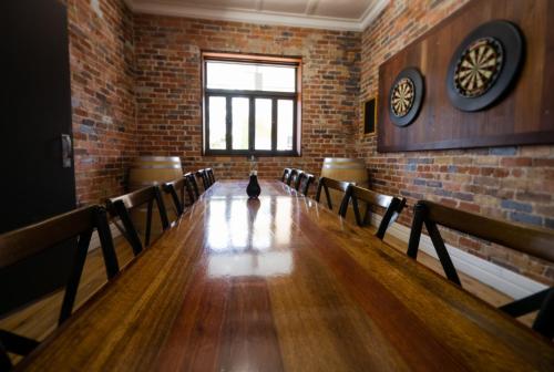 a cat sitting at the end of a long table in a room at Royal Hotel Guyra in Guyra