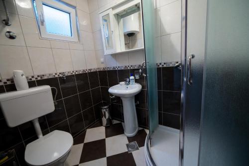 a bathroom with a toilet and a sink and a shower at Apartments Pavićević in Tivat