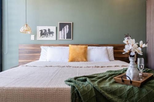 sypialnia z łóżkiem z wazonem kwiatów w obiekcie Master skyline balcony suite / Limpieza diaria w mieście Guadalajara