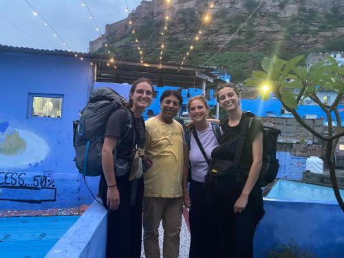 a group of people standing in front of a blue wall at Pushp Guest House in Jodhpur