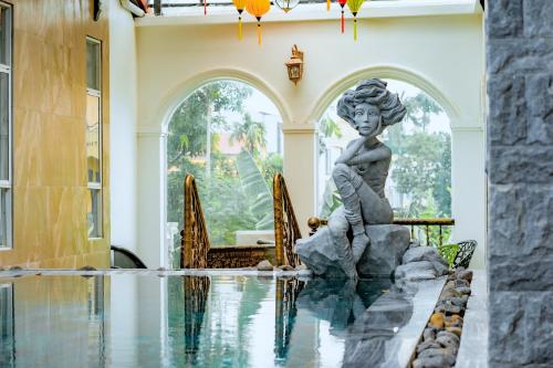 順化的住宿－HELLO VILLA & SPA，一座房子中游泳池中间的雕像