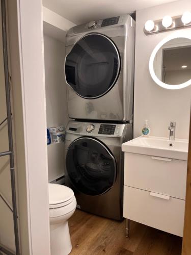 baño pequeño con lavadora y lavamanos en Neat, compact, private room in a lovely Vancouver neighbourhood, en Vancouver