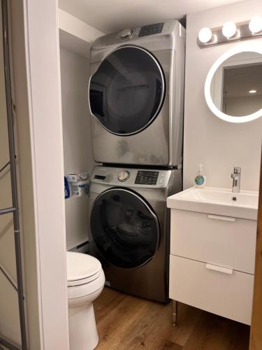 a small bathroom with a washing machine and a sink at Compact private room, private bathroom, laundry & free parking in a lovely Vancouver neighborhood in Vancouver