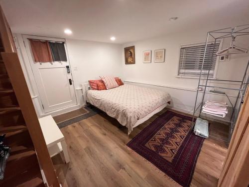 a small bedroom with a bed and a window at Compact private room, private bathroom, laundry & free parking in a lovely Vancouver neighborhood in Vancouver