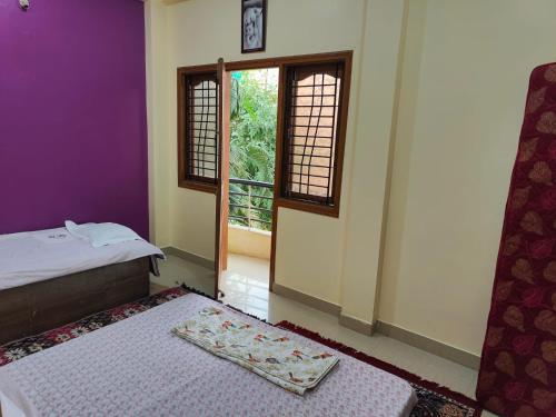 a bedroom with a bed and a door with a window at Om Paradise in Ujjain