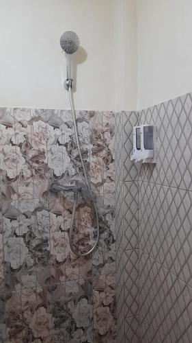 a shower with a shower head in a bathroom at Homestay morelia in Labuan Bajo