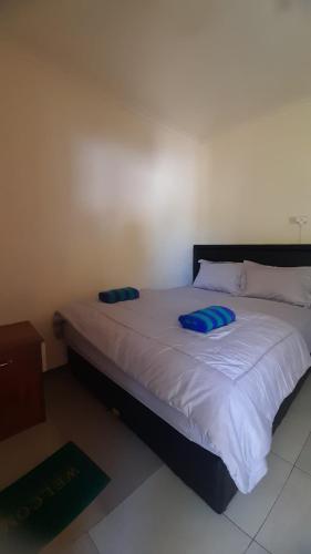 Un dormitorio con una cama con almohadas azules. en Homestay morelia en Labuan Bajo