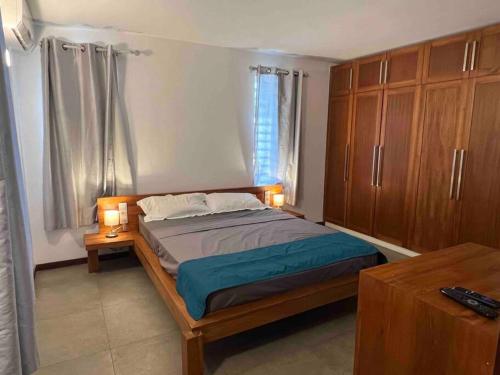 a bedroom with a bed with two lamps and a table at Villa luxueuse - Pointe aux Sables in Pointe aux Sable