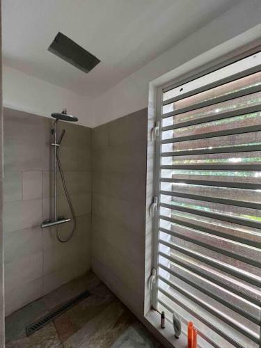 a bathroom with a shower and a window at Villa luxueuse - Pointe aux Sables in Pointe aux Sable
