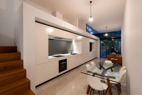 a kitchen and dining room with a glass table and chairs at Paddington House in Sydney