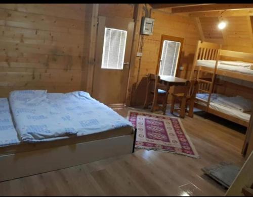 een slaapkamer met een bed, een tafel en een stoel bij Villat Mulliri in Peje