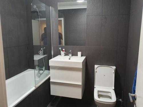 W łazience znajduje się umywalka, toaleta i lustro. w obiekcie Double Room with Shared Bathroom w Londynie